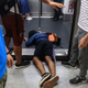 A man falls down during a protest to prevent commuters from reaching work in business districts at Lai King MTR station in Hong Kong on Aug. 5, 2019.